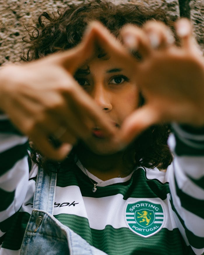 Portrait of a young woman wearing a Sporting Portugal jersey, captured outdoors in Cuenca, Ecuador.